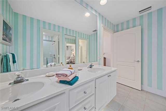 ensuite bathroom featuring ensuite bathroom, a sink, visible vents, and wallpapered walls