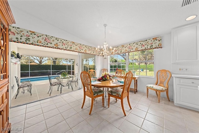 dining space featuring lofted ceiling, light tile patterned floors, visible vents, and a chandelier