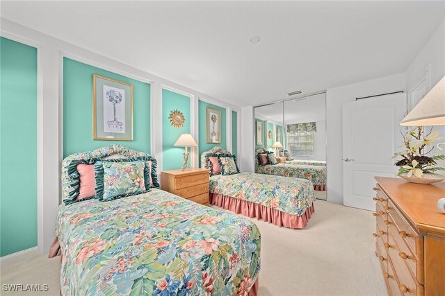 bedroom featuring light carpet, visible vents, and a closet