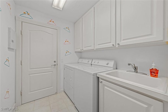 clothes washing area with cabinet space, light tile patterned flooring, a sink, and washing machine and clothes dryer