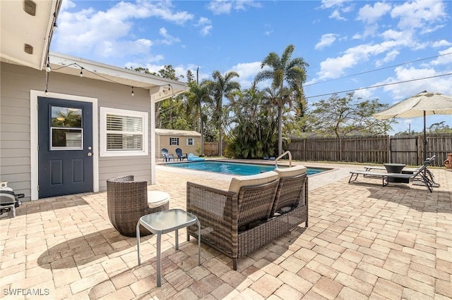 view of pool with a patio area and a shed