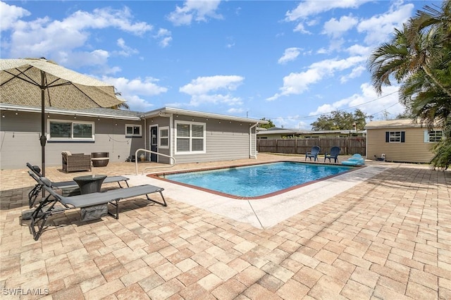 view of pool featuring a patio and a storage unit