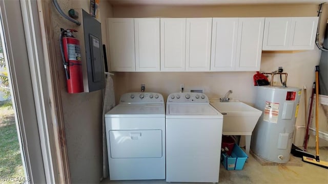 clothes washing area featuring cabinets, electric water heater, sink, and independent washer and dryer