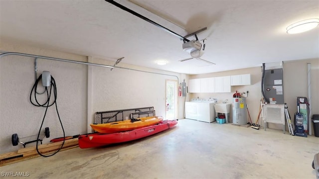 garage featuring sink, a garage door opener, independent washer and dryer, electric water heater, and heating unit