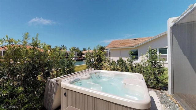 view of pool with a hot tub and a water view