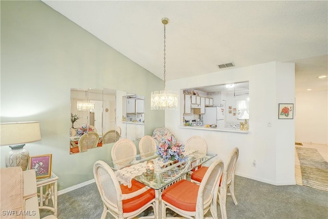 carpeted dining room with high vaulted ceiling