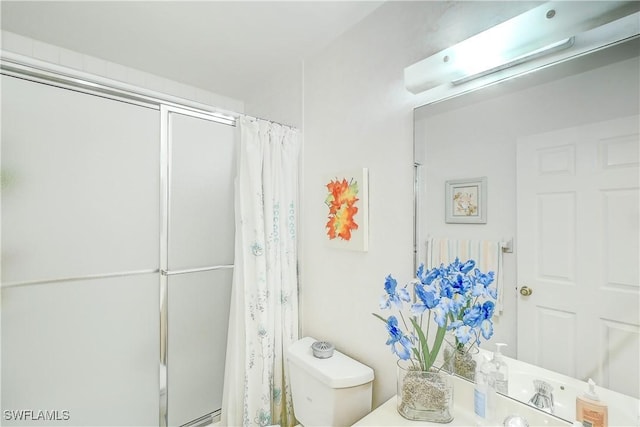 bathroom featuring walk in shower, vanity, and toilet