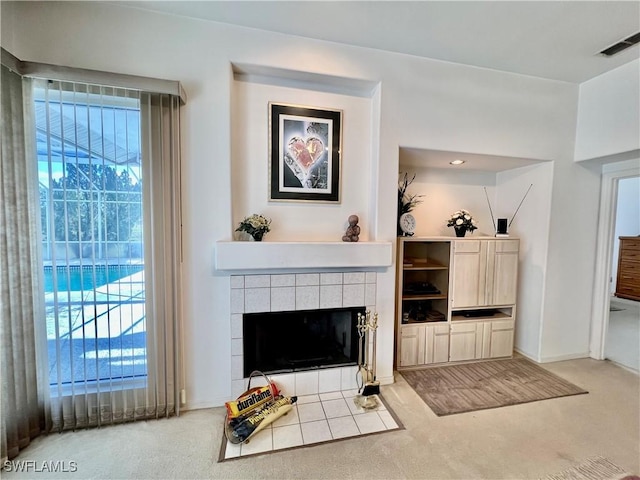 carpeted living area featuring a fireplace and visible vents