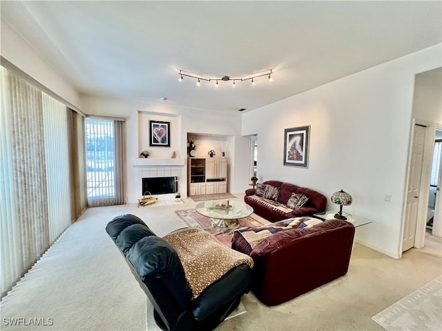 carpeted living room with a tile fireplace