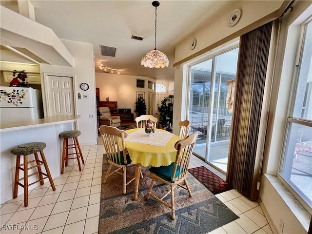 dining space with visible vents, light tile patterned flooring, and a wealth of natural light