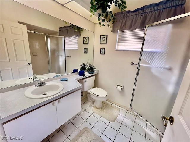 bathroom featuring toilet, a shower stall, vanity, and tile patterned floors