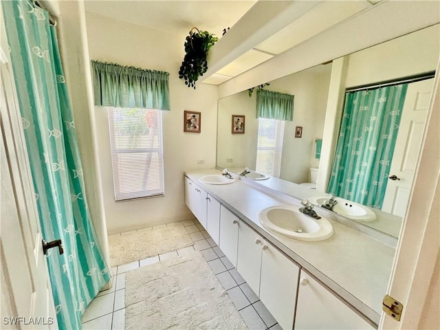 bathroom with double vanity, a sink, and tile patterned floors