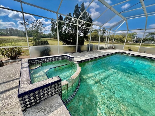 outdoor pool featuring an in ground hot tub, a patio, and a lanai