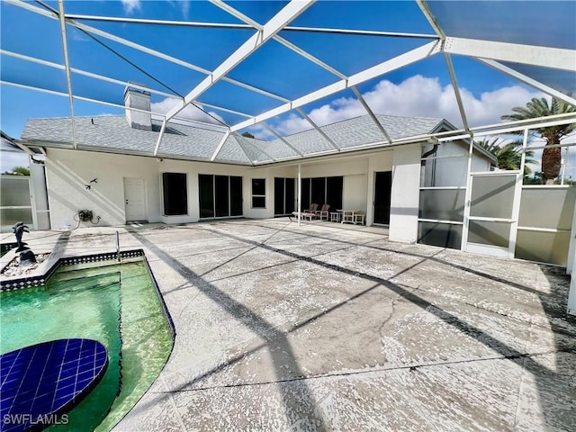 exterior space with roof with shingles, a patio, stucco siding, a lanai, and an outdoor pool