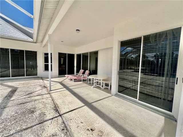 view of patio featuring a lanai