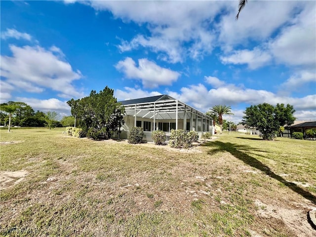 back of property with a lanai and a lawn