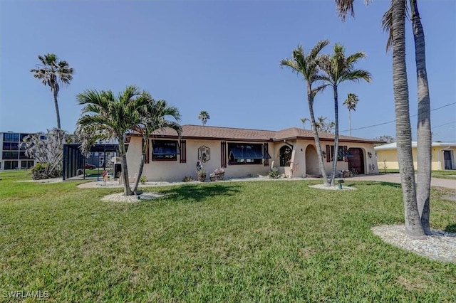 single story home featuring a garage and a front lawn