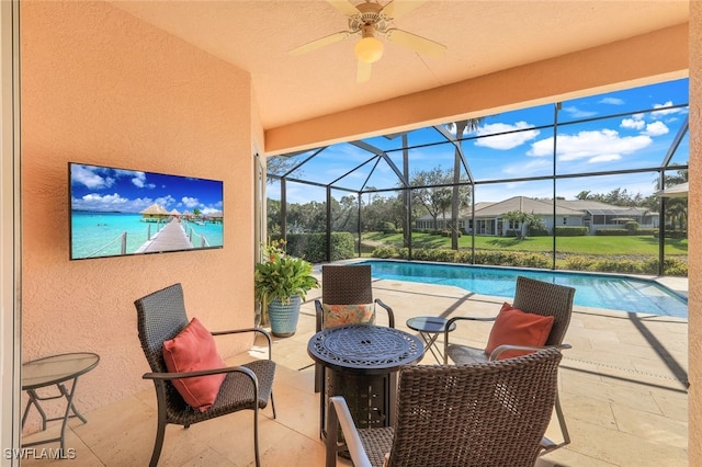 view of swimming pool with ceiling fan, a lanai, and a patio