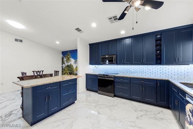 kitchen featuring appliances with stainless steel finishes, blue cabinets, tasteful backsplash, a center island, and ceiling fan