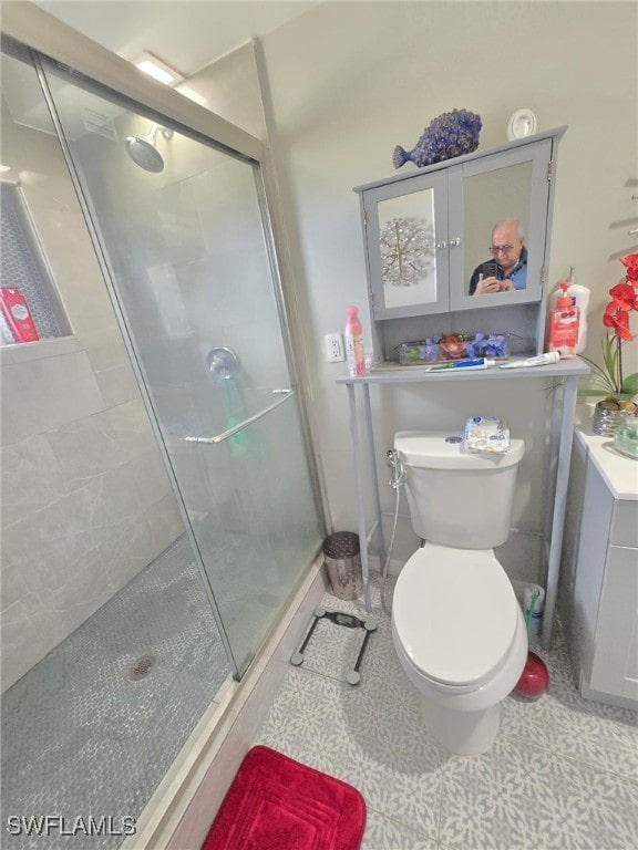 bathroom featuring toilet and a shower with door