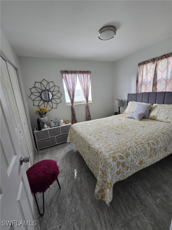 bedroom with dark wood-type flooring and a closet