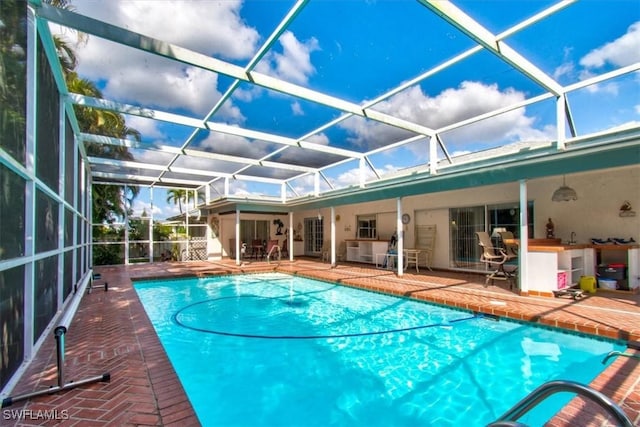 view of swimming pool featuring a lanai and a patio area