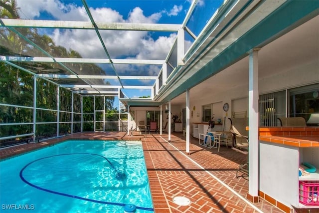 view of swimming pool featuring a lanai and a patio area