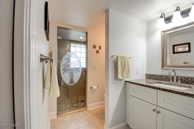 bathroom featuring tiled shower, vanity, toilet, and tile patterned flooring