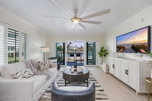 living room with ornamental molding, ceiling fan, and light wood-type flooring