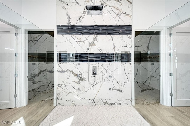 bathroom with hardwood / wood-style floors and tiled shower