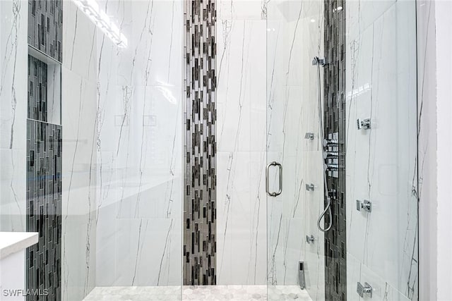 bathroom featuring a marble finish shower