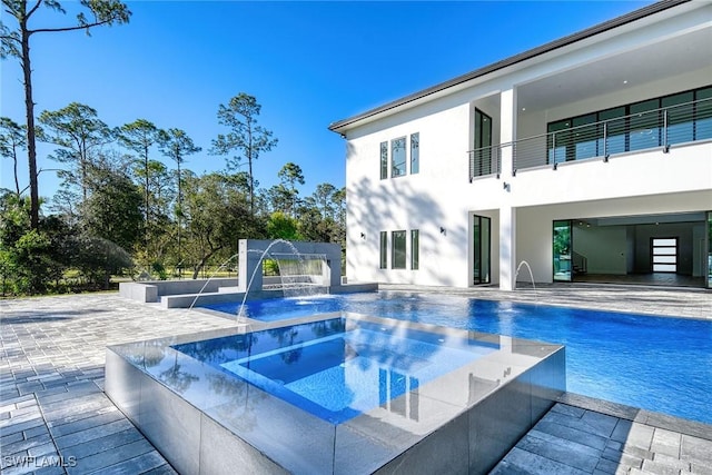 view of pool featuring an in ground hot tub, pool water feature, and a patio area