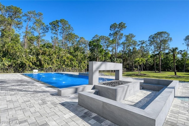 view of pool featuring a patio and an outdoor fire pit