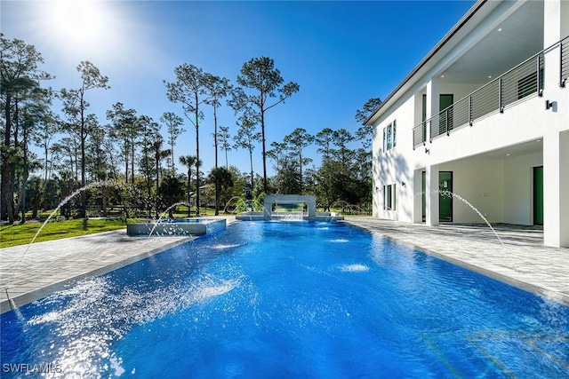 view of swimming pool with a patio, pool water feature, and an in ground hot tub