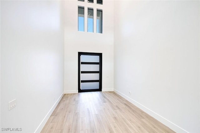 foyer entrance featuring a high ceiling and light hardwood / wood-style floors