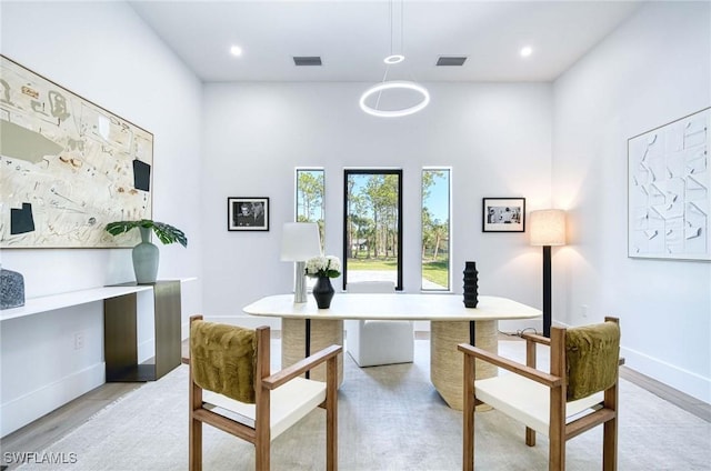 home office with visible vents, light wood-type flooring, and baseboards