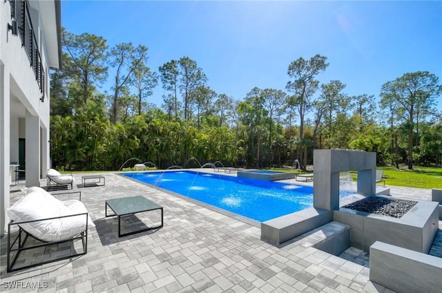 view of swimming pool with a patio area and a pool with connected hot tub