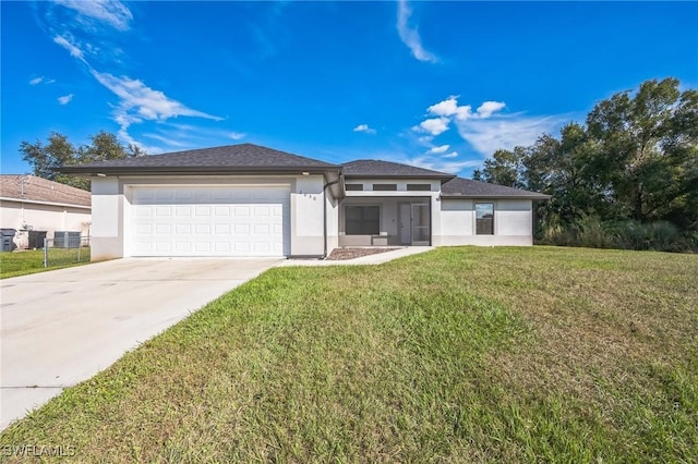 prairie-style home with a garage, central AC, and a front lawn