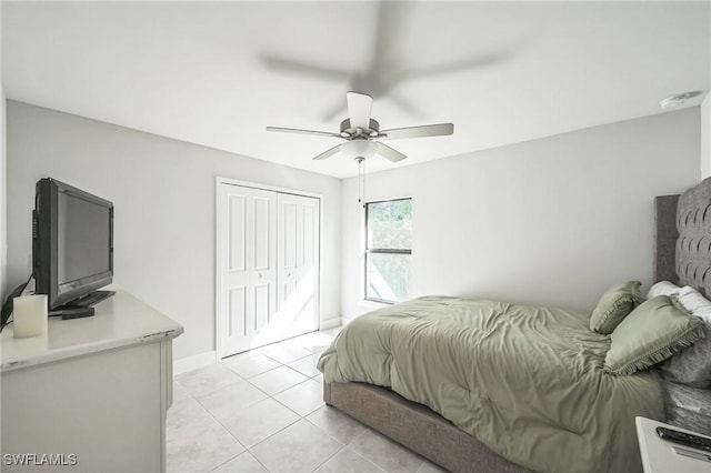 bedroom featuring light tile patterned floors, a closet, and ceiling fan