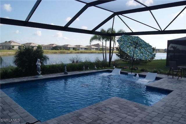 view of pool with a patio, a water view, pool water feature, and glass enclosure