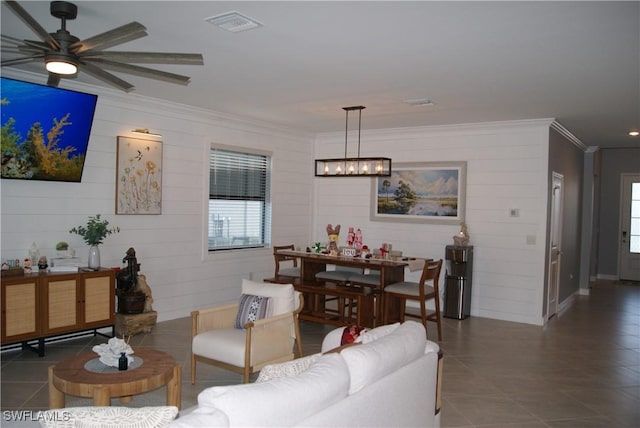 tiled living room with crown molding, ceiling fan with notable chandelier, and a wealth of natural light