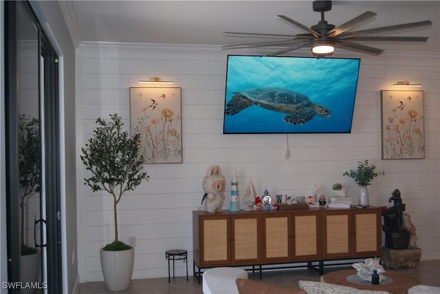 living room with ornamental molding and ceiling fan