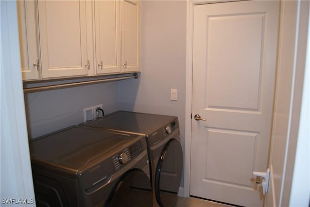 washroom featuring cabinets and washer and dryer