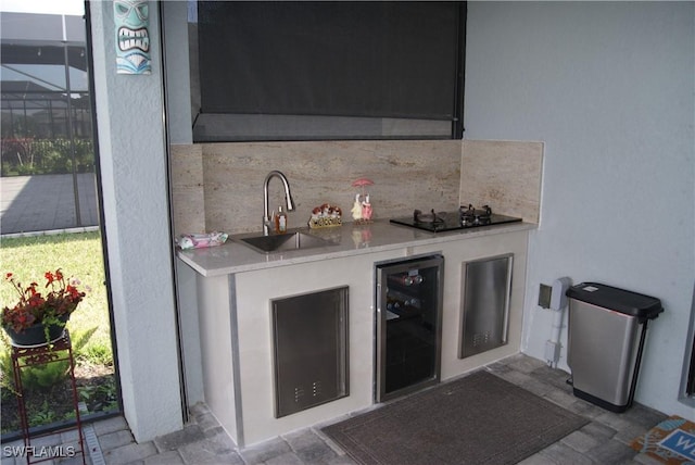 bar with wine cooler, sink, a wealth of natural light, black gas stovetop, and backsplash