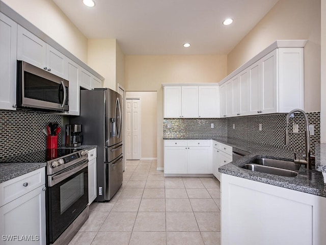 kitchen featuring light tile patterned flooring, sink, tasteful backsplash, stainless steel appliances, and white cabinets