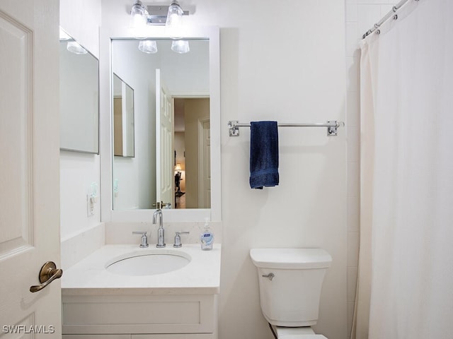 bathroom with vanity, a shower with shower curtain, and toilet