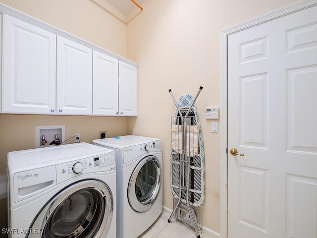 laundry area with cabinets, separate washer and dryer, and light tile patterned floors