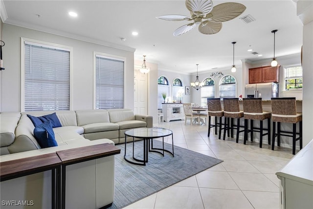 tiled living room featuring ornamental molding and ceiling fan with notable chandelier