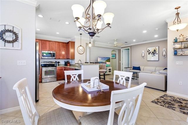 tiled dining area with sink, ornamental molding, and ceiling fan