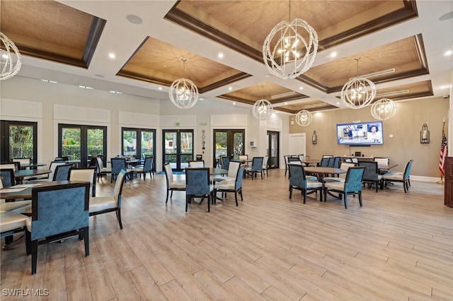 dining room with french doors, a chandelier, a high ceiling, and light wood-type flooring